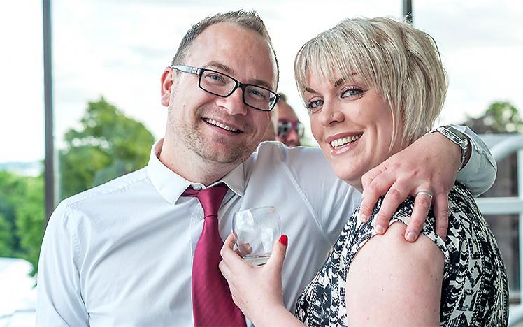 Man and Woman smiles for the camera wearing smart clothing