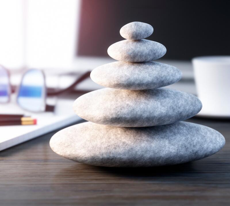 relaxation stones, on a desk with notebook, glasses, cup, pens and penicls