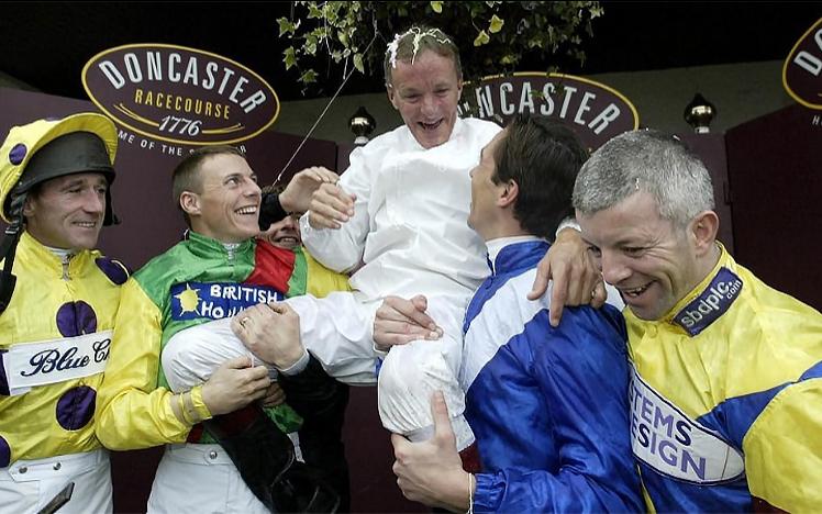 Jockeys raise the winning jockey on their sholders
