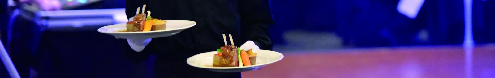 A member of waitign staff at Doncaster Races carrying plates