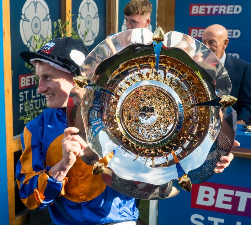Tom Marquand holding the St Leger Day Trophy after winning the St Leger at Doncaster Racecourse.