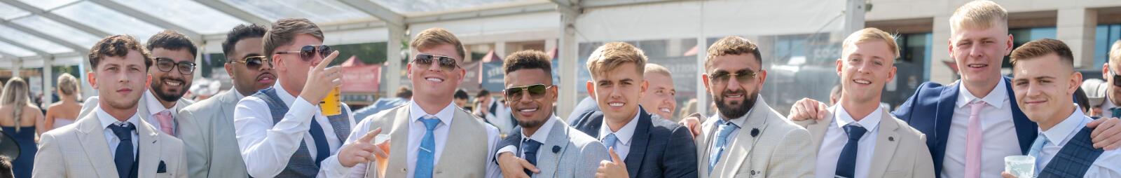 A large group of guys in suits enjoying Doncaster Races