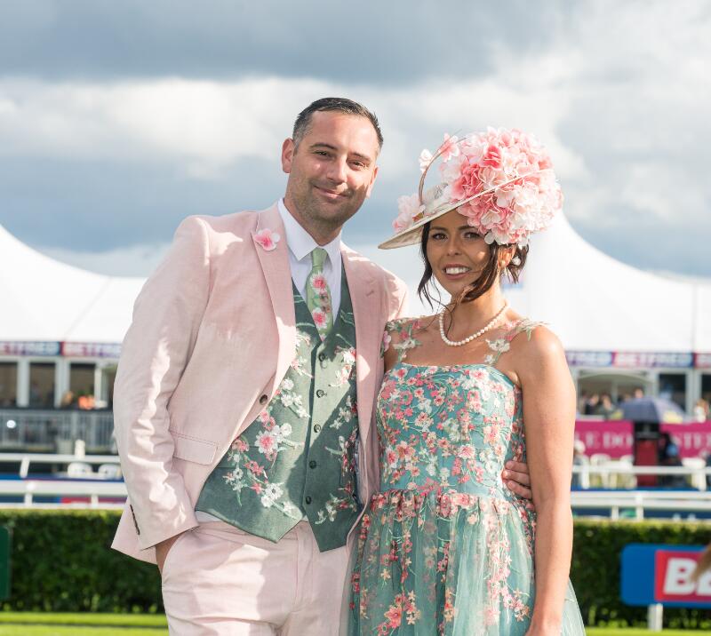 A couple at the St Leger Festival on Ladies' Day dressed smart in light pink and green outfits.