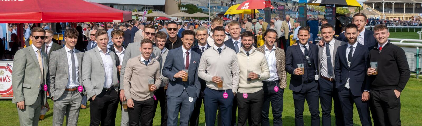 A large group of guys enjoying Doncaster Races