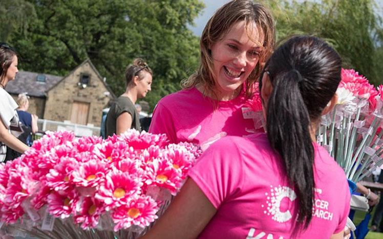 To racegoers wearing brightly coloured t-shirts with charity logos on them.