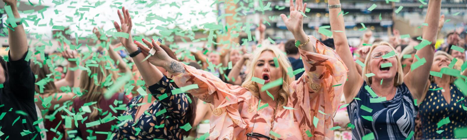 Race goers dancing under confetti during entertainment at Doncaster Racecourse
