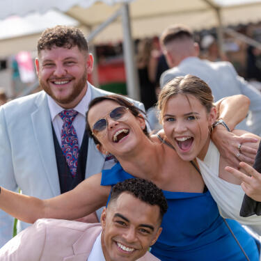 Group of 4 people enjoying themselves on the Champagne Lawn at Doncaster Racecourse
