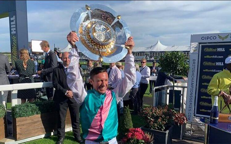 Frankie Dettori holds his winners trophy in the air.