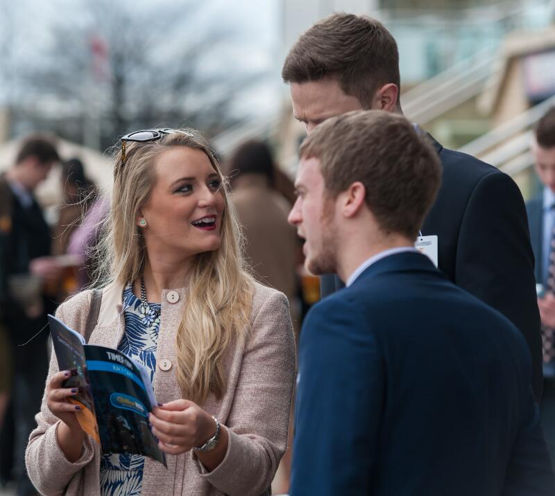 A small group of racegoers at Doncaster study the race card