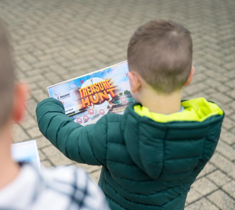Child holding a treasure map at the racecourse 