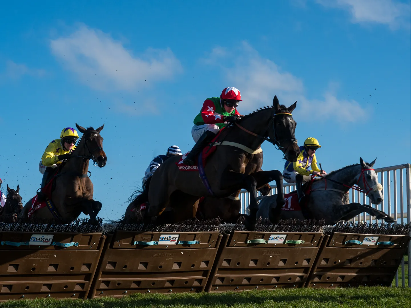 Horses jumping over hurdles at Cheltenham Gold Cup Day at Doncaster Racecourse