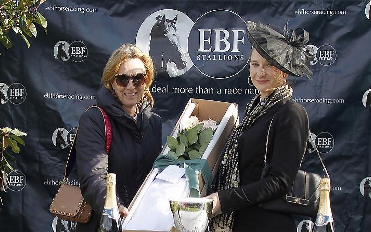 Two women pose for a photo with flowers from the British EBF Breeders