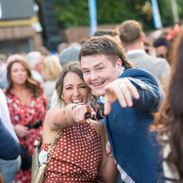 A couple dancing and pointing to the camera on Betfred St Leger Day