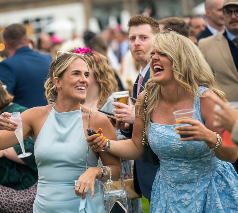 Two girls laughing and joking at Doncaster Racecourse