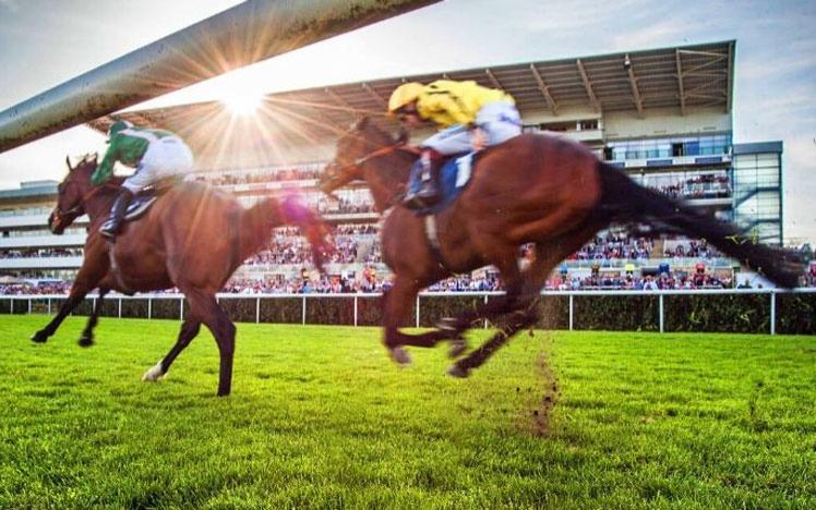 Two jockeys racing past the grandstand at Doncaster Racecourse.