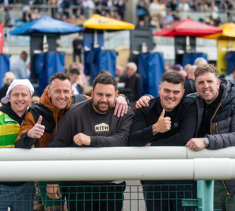 A group of guys in front of the betting stands at Doncaster Racecourse