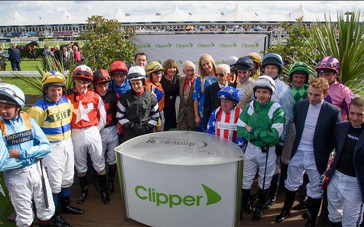 A collection of jokeys pose for a group photo