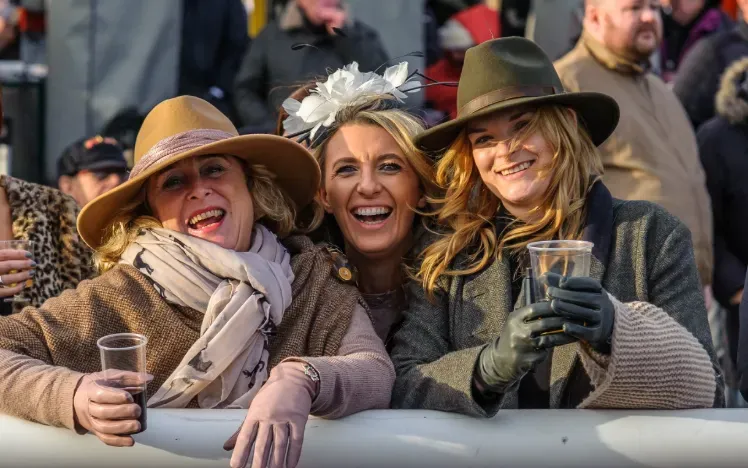 Three women enjoying the races during autumn