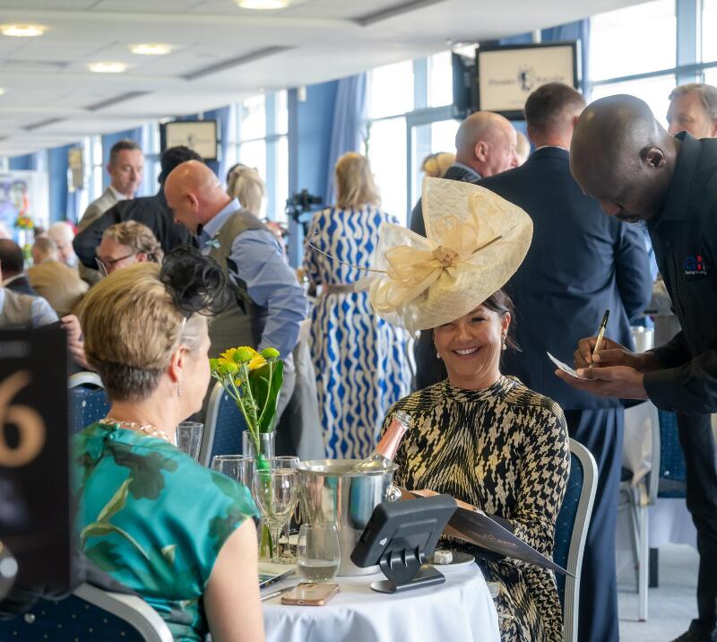 Race goer in a fascinator enjoying hospitality at Doncaster