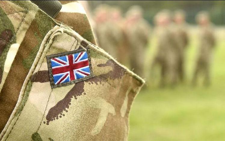 A UK army badge on the sholder of a soldier.