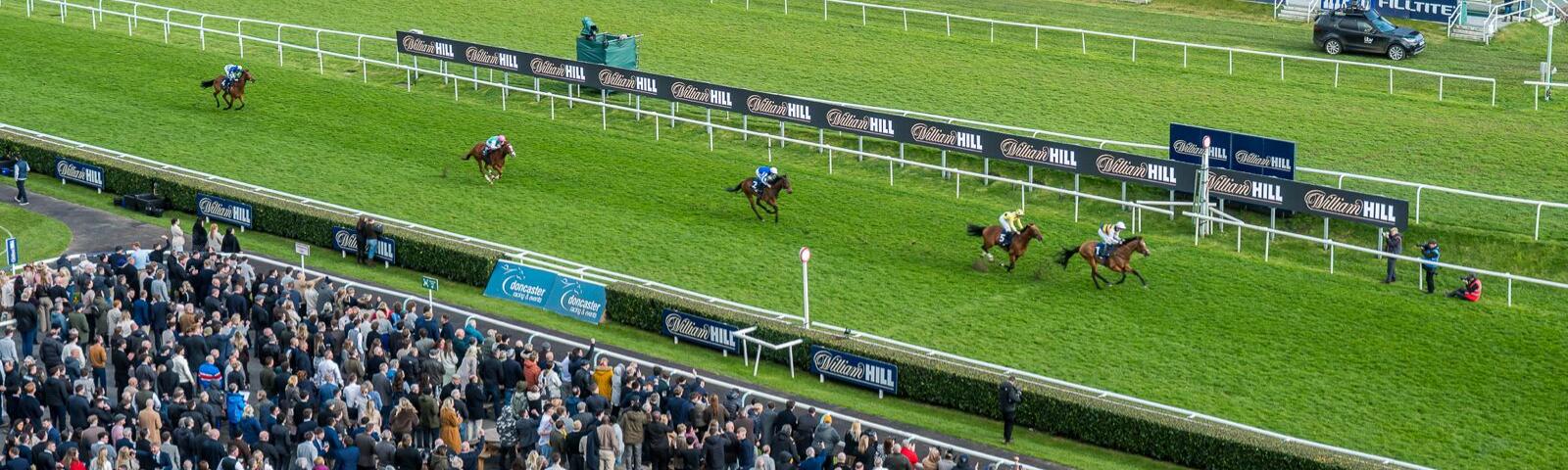 Horses running on the flat track at Doncaster Racecourse 
