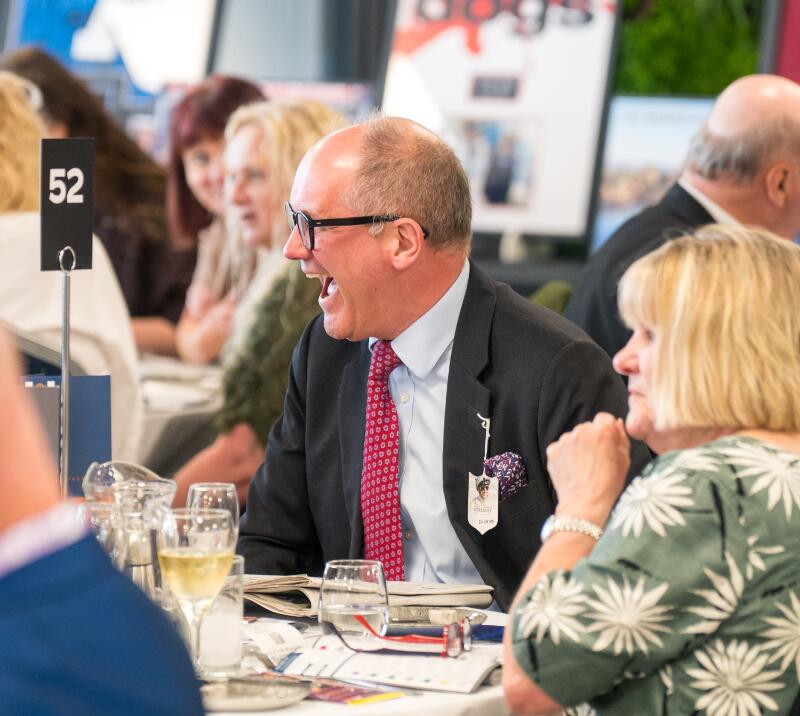 A gent laughing whilst enjoying hospitality at Doncaster Racecourse