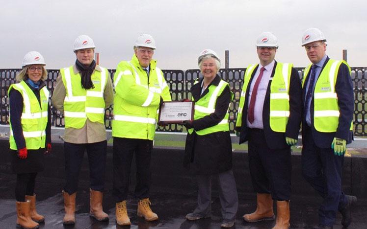 Members of the Doncaster Racecourse team holding a certificate of official topping out of the new hotel building.